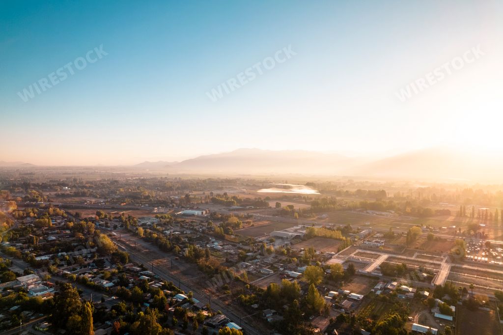 An aerial cityscape of Amanecer en Paine, Chile filled with sun rays