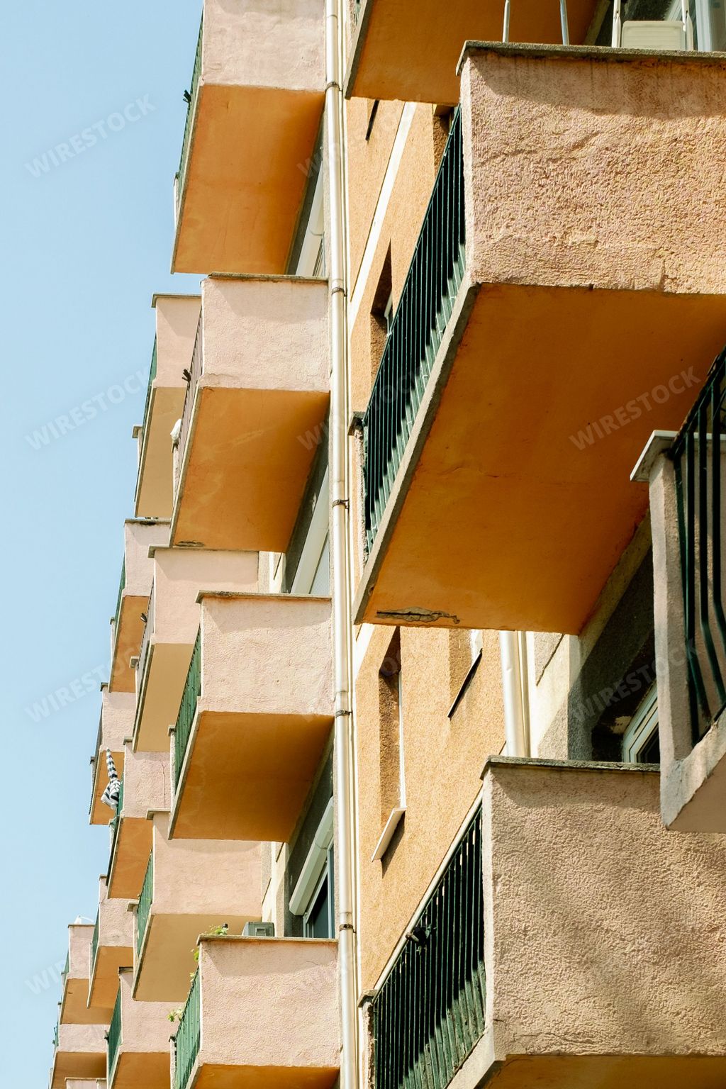 A vertical shot of a modern building in Budapest, Hungary with windows and balconies facing outward