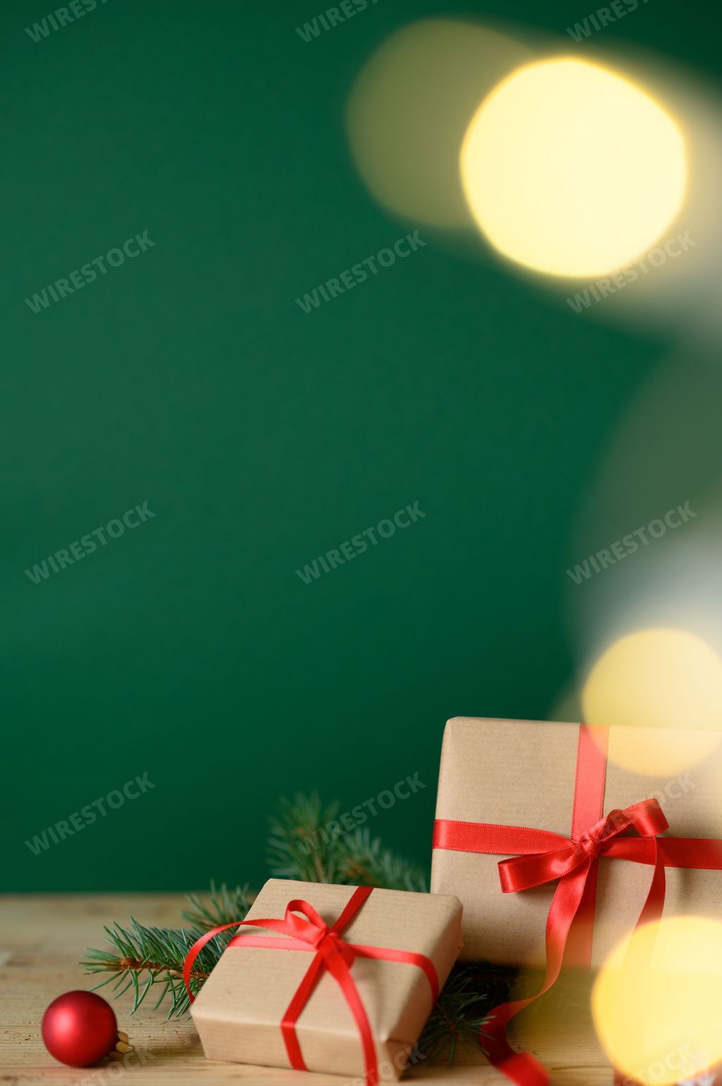 A vertical shot of Christmas presents against a green background