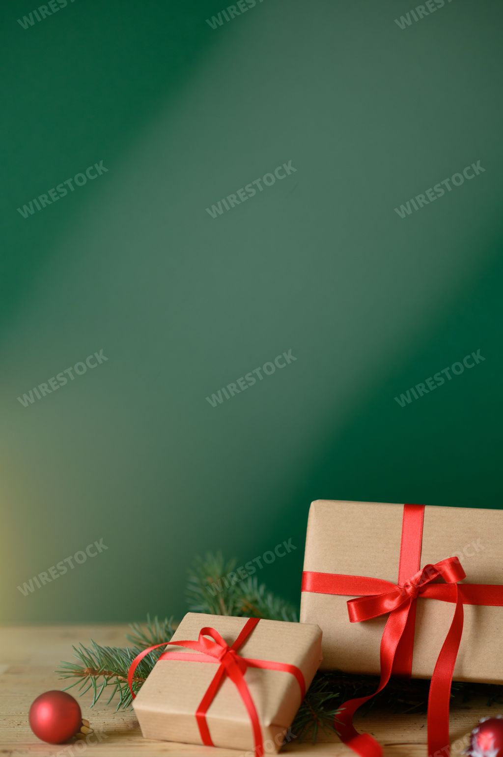 A vertical shot of Christmas presents against a green background