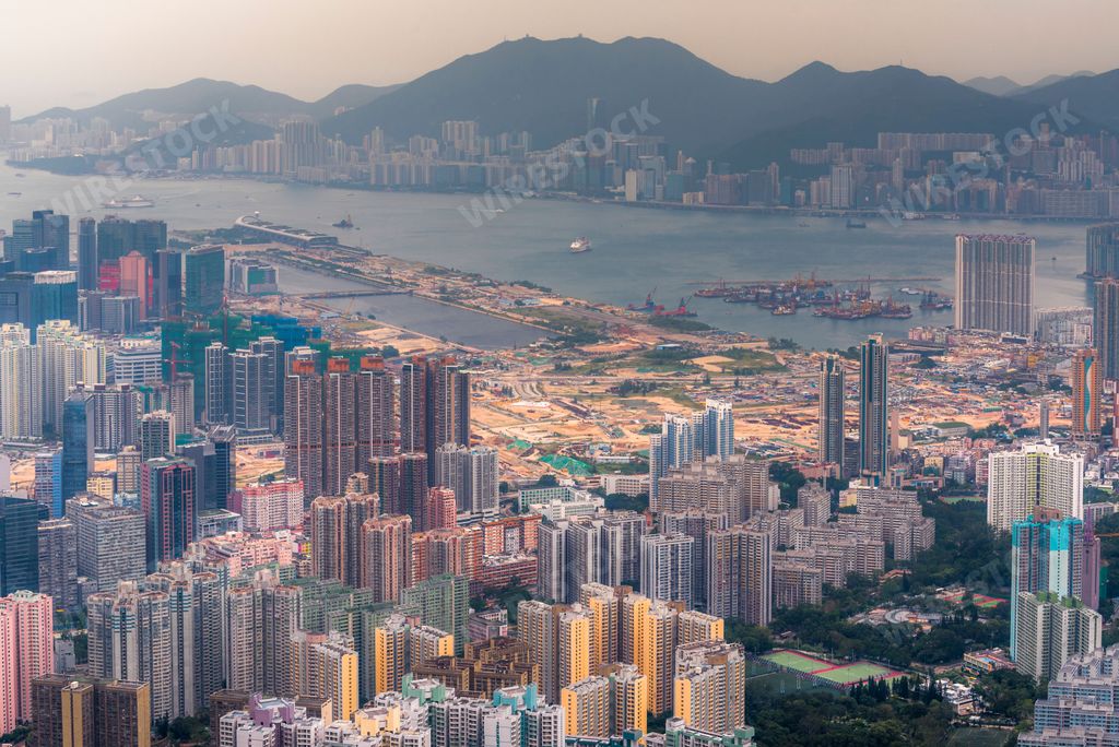 An aerial view of the skyline of the city of Hong Kong and mountains on the horizon during daytime, China