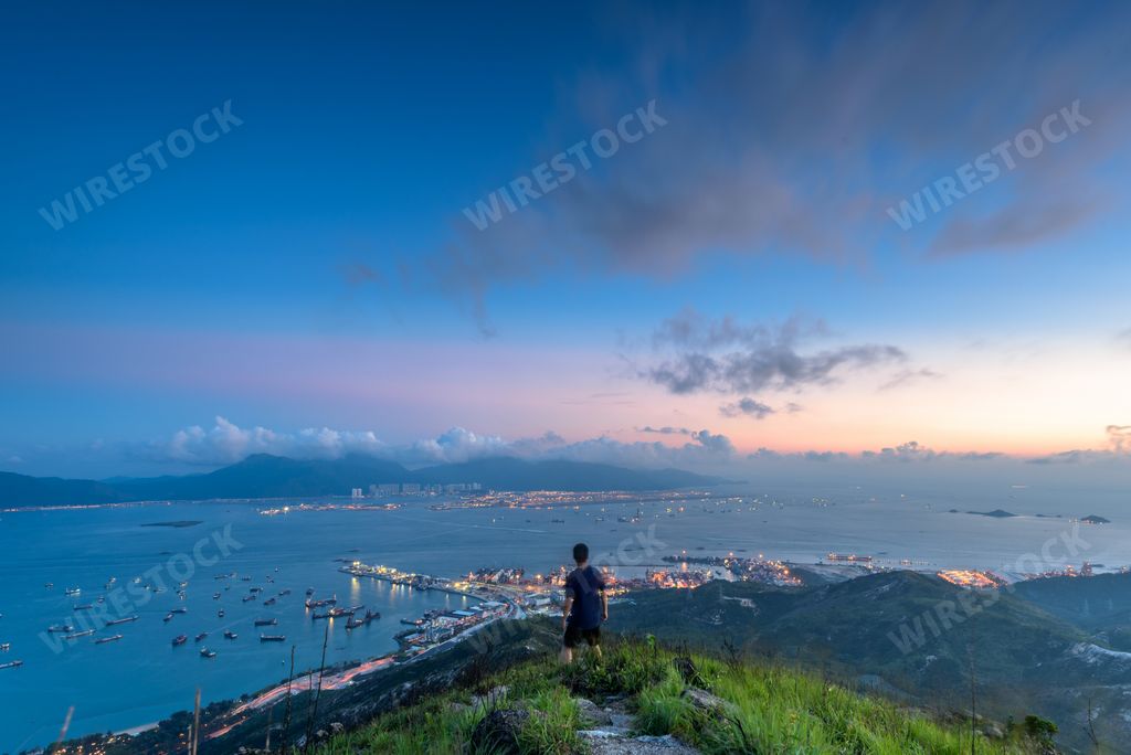 The beautiful view of a cloudy sky  during the sunset and boy standing on the mountain