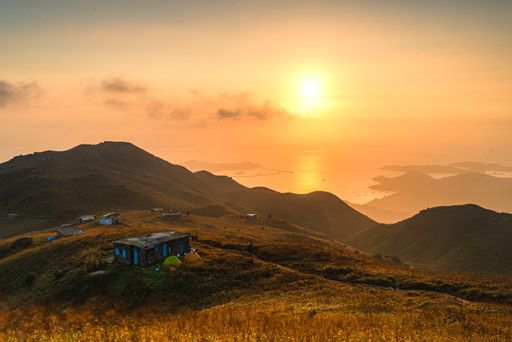Beautiful sunrise in a rural area with mountains Stock photo | Wirestock