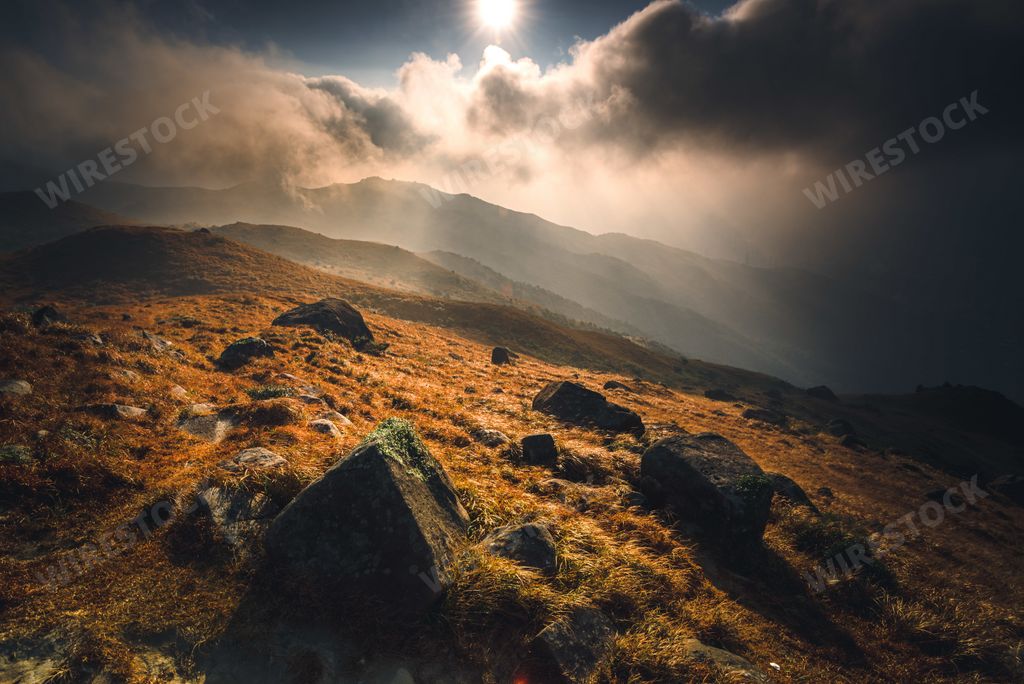 A mountain with stones and a shining sun during the sunrise