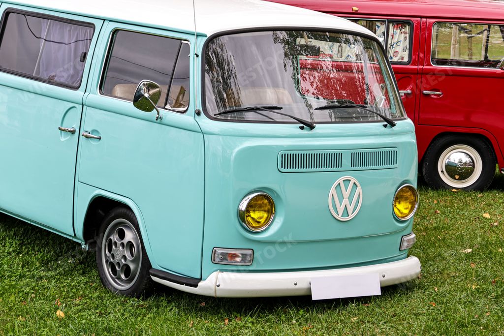 A beautiful bright turquoise classic Volkswagen transporter van on a field