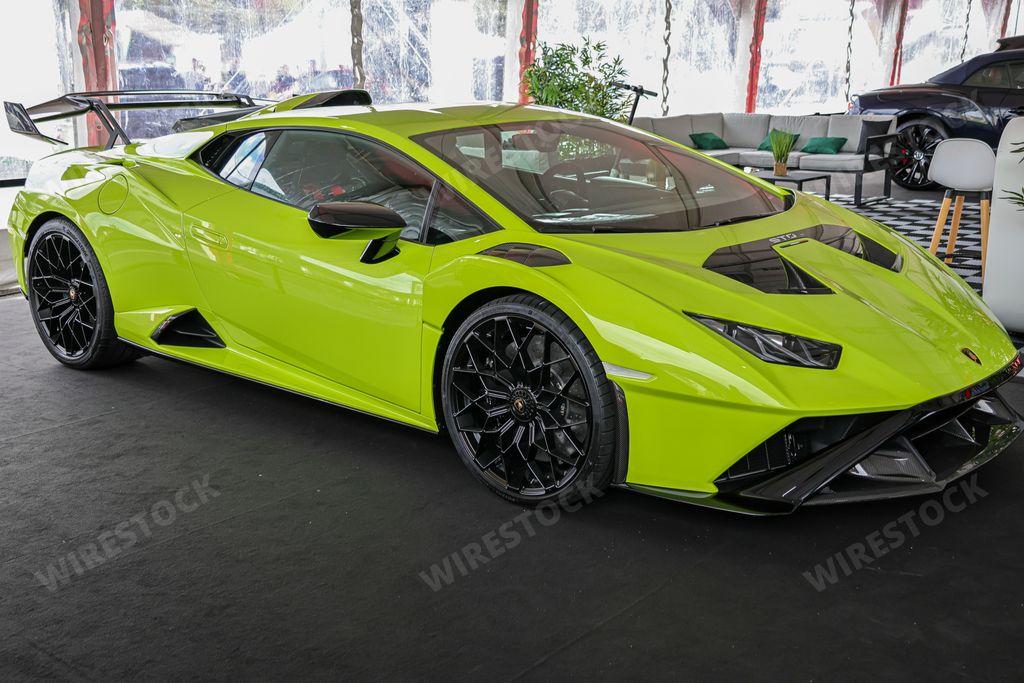 A side view of a beautiful light green Lamborghini Huracan STO on a sunny day
