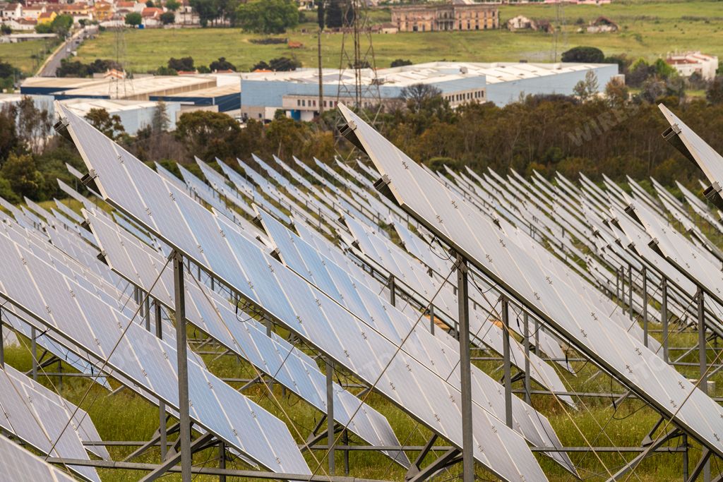 A view of solar panels in a field under the cloudy sky