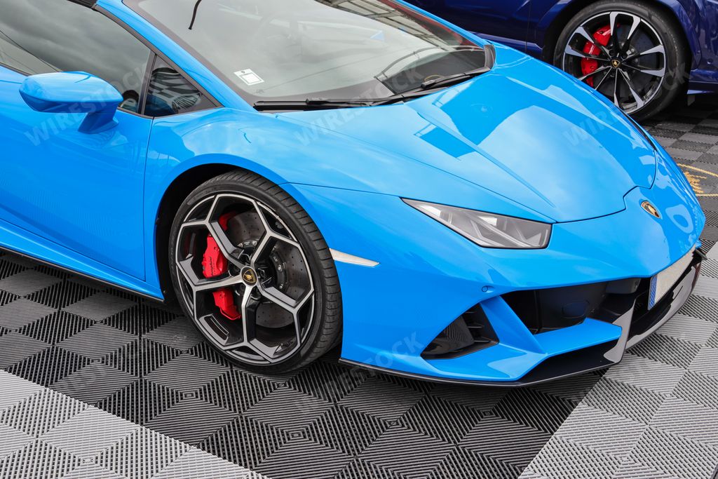A closeup of a blue sports car Lamborghini standing on the road