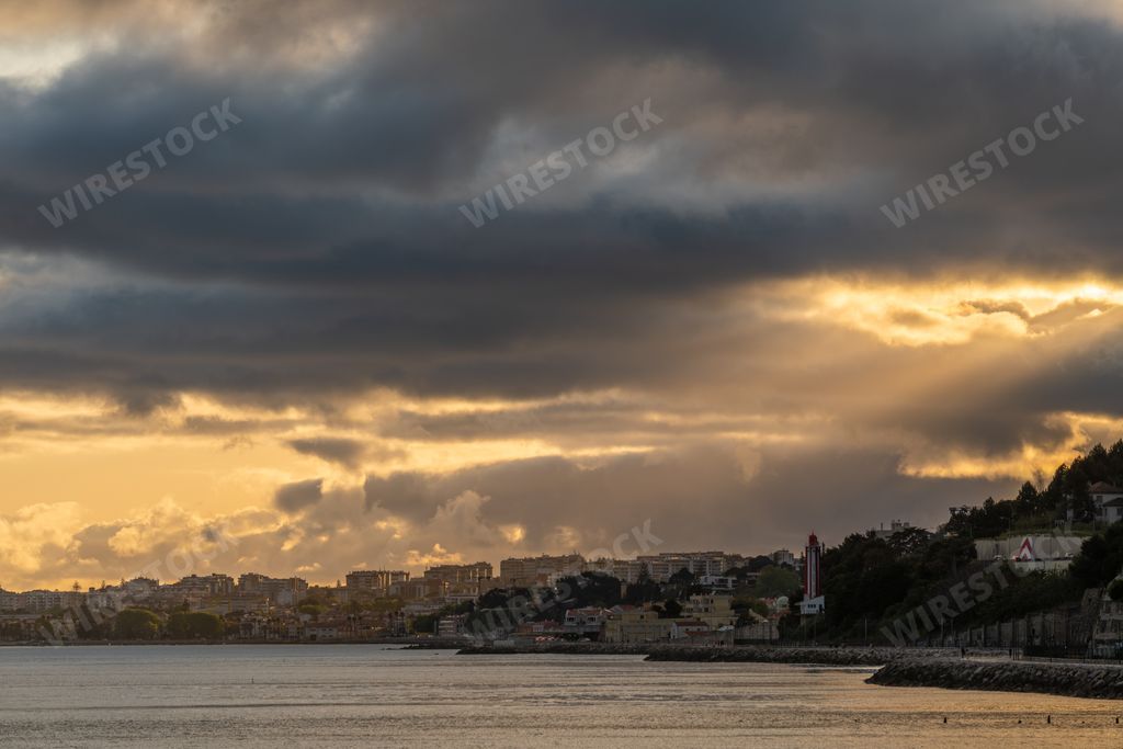 A scenic view of sunset at Cruz Quebrada beach in Lisbon, Portugal in cloudy sky background