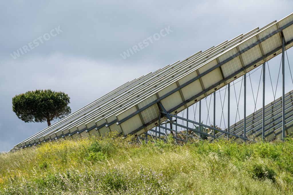 A view of solar panels in a field under the cloudy sky