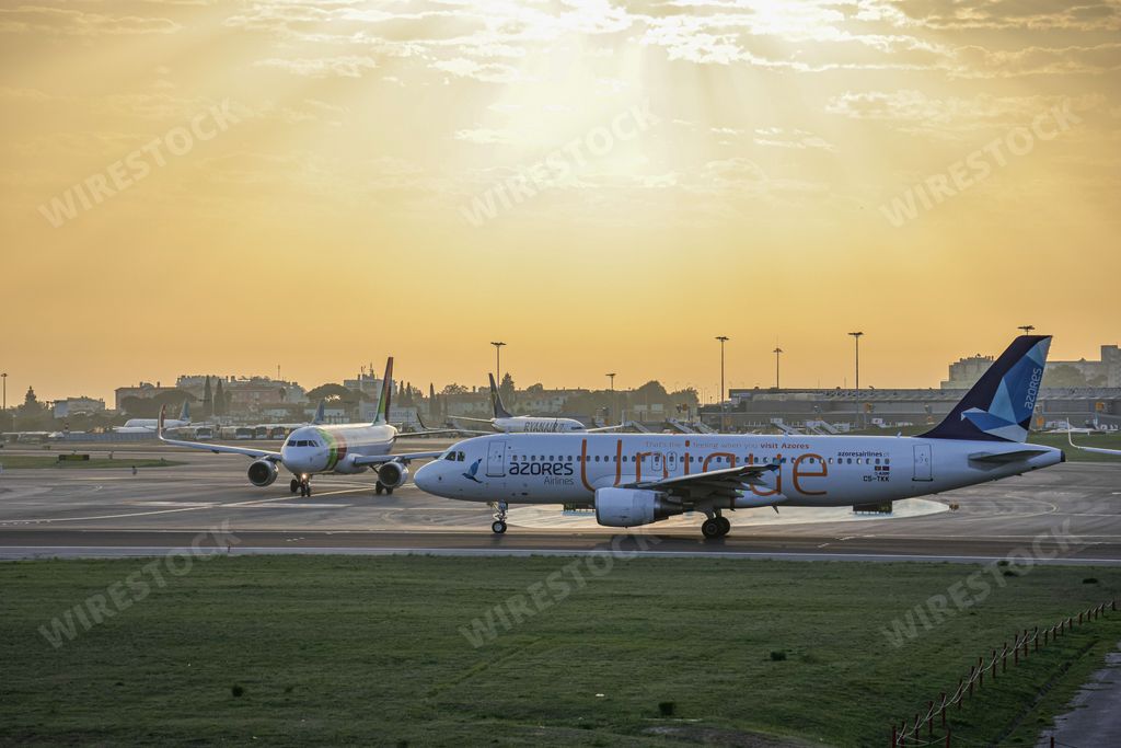 The view of airplanes parked in the Humberto Delgado Airport at sunset