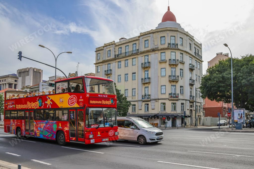 A red double-decker city sightseeing tourist bus in the city of Lisbon, Portugal