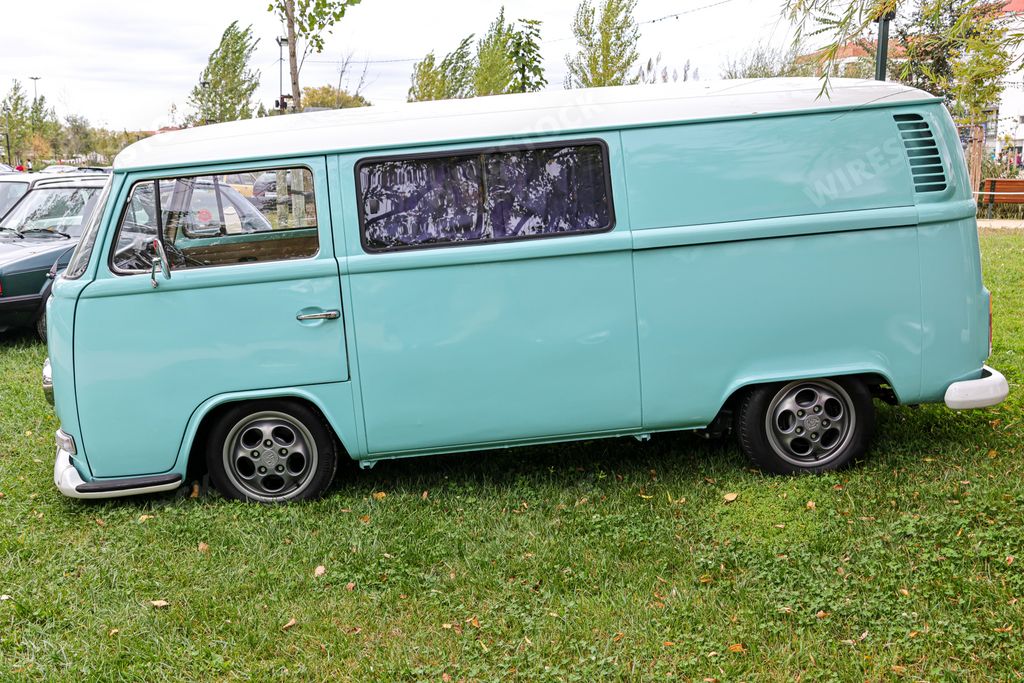 A beautiful bright turquoise classic Volkswagen transporter van on a field