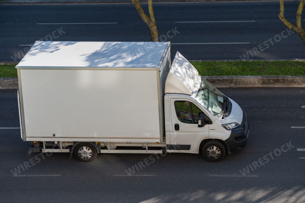 A white big truck driving in the street of Lisbon