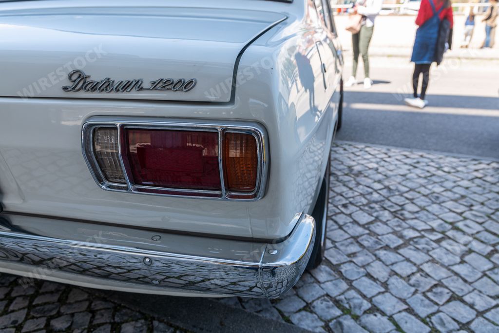 The backside of a white Datsun Model 1200 car released in 1970 in the street in Portugal
