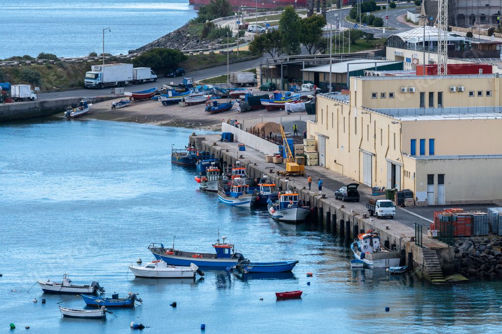 An aerial shot of fishing boats moored in a harbor in Sines, Portugal