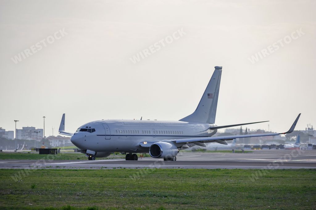 A Boeing C-40C airplane of the US Air Force, at Lisbon airport at sunrise, surrounded by a green lawn