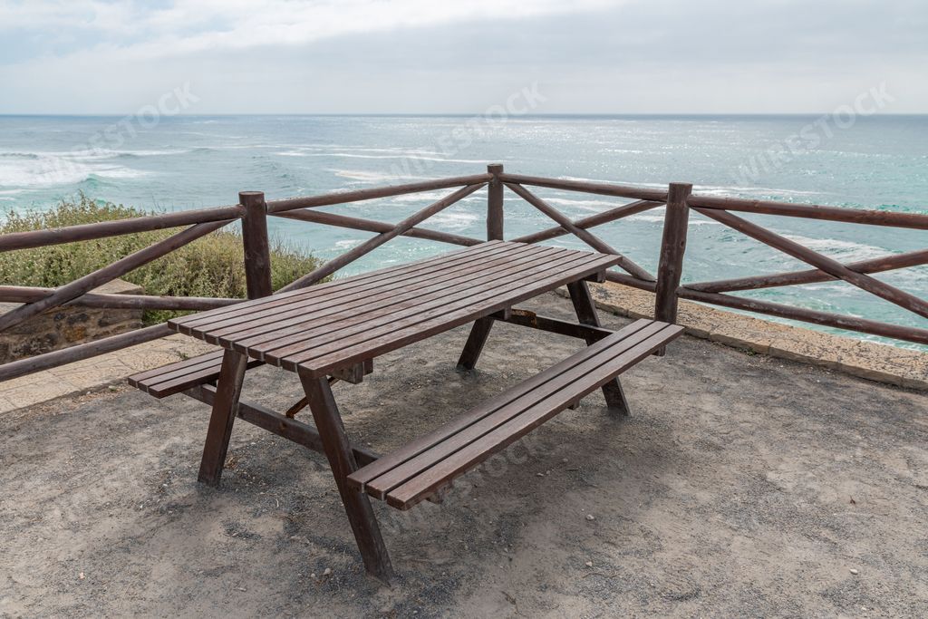 A wooden picnic table overlooking the ocean