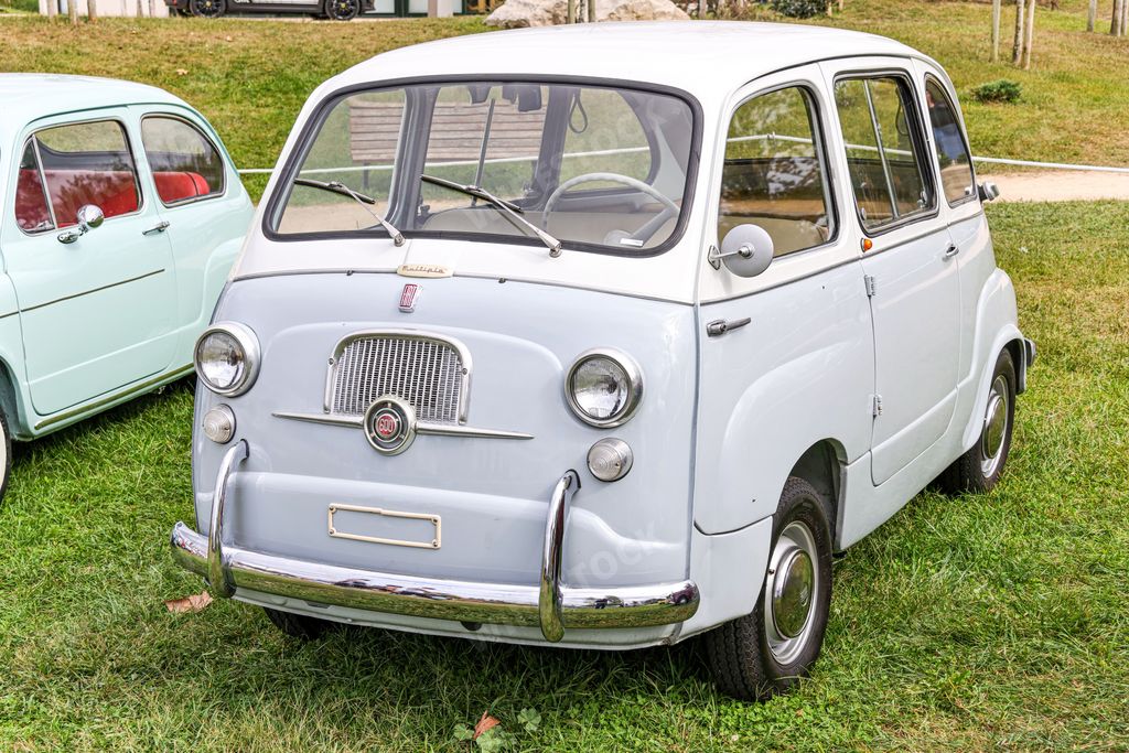 A front view of a classic white Fiat model 600 in a field