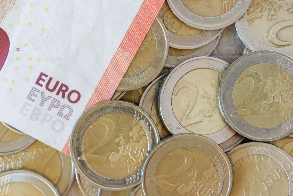 A closeup shot of several two euro coins and a ten euro banknote