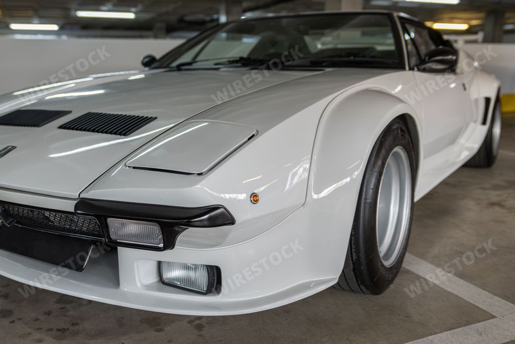 A closeup of the front view of a white vintage Lotus model Esprit car in a garage