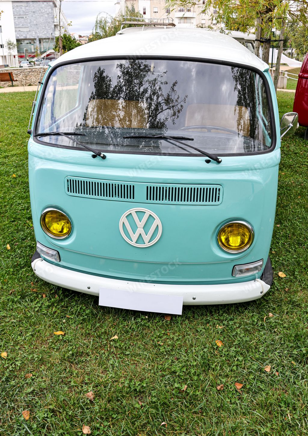 A beautiful bright turquoise classic Volkswagen transporter van on a field