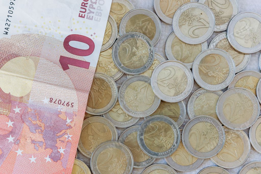 A closeup shot of several two euro coins and a ten euro banknote