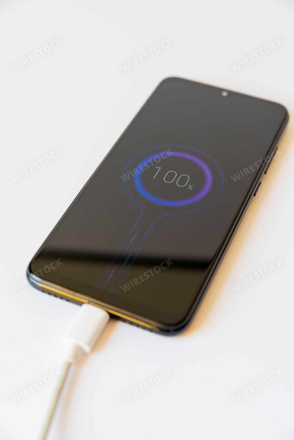 Mobile phone charging with 100 percent battery isolated on white background