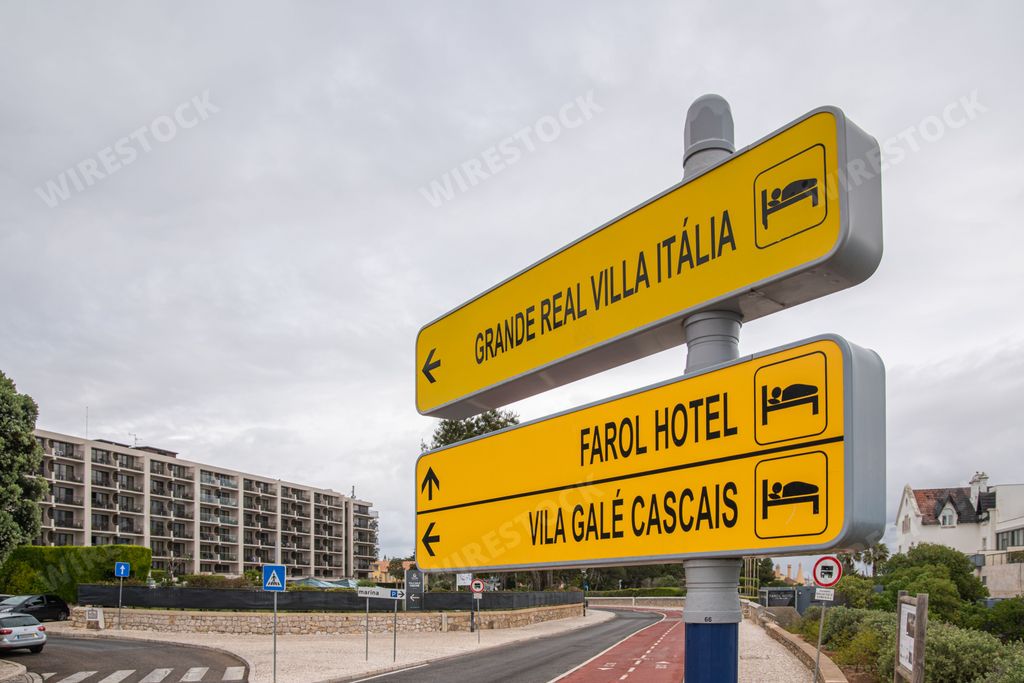 A yellow direction board with information about several hotels in Cascais, Portugal