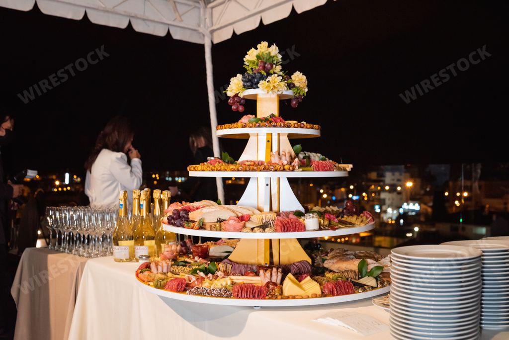 A closeup of delicious fresh fruit, cheese and bread on stand at wedding table