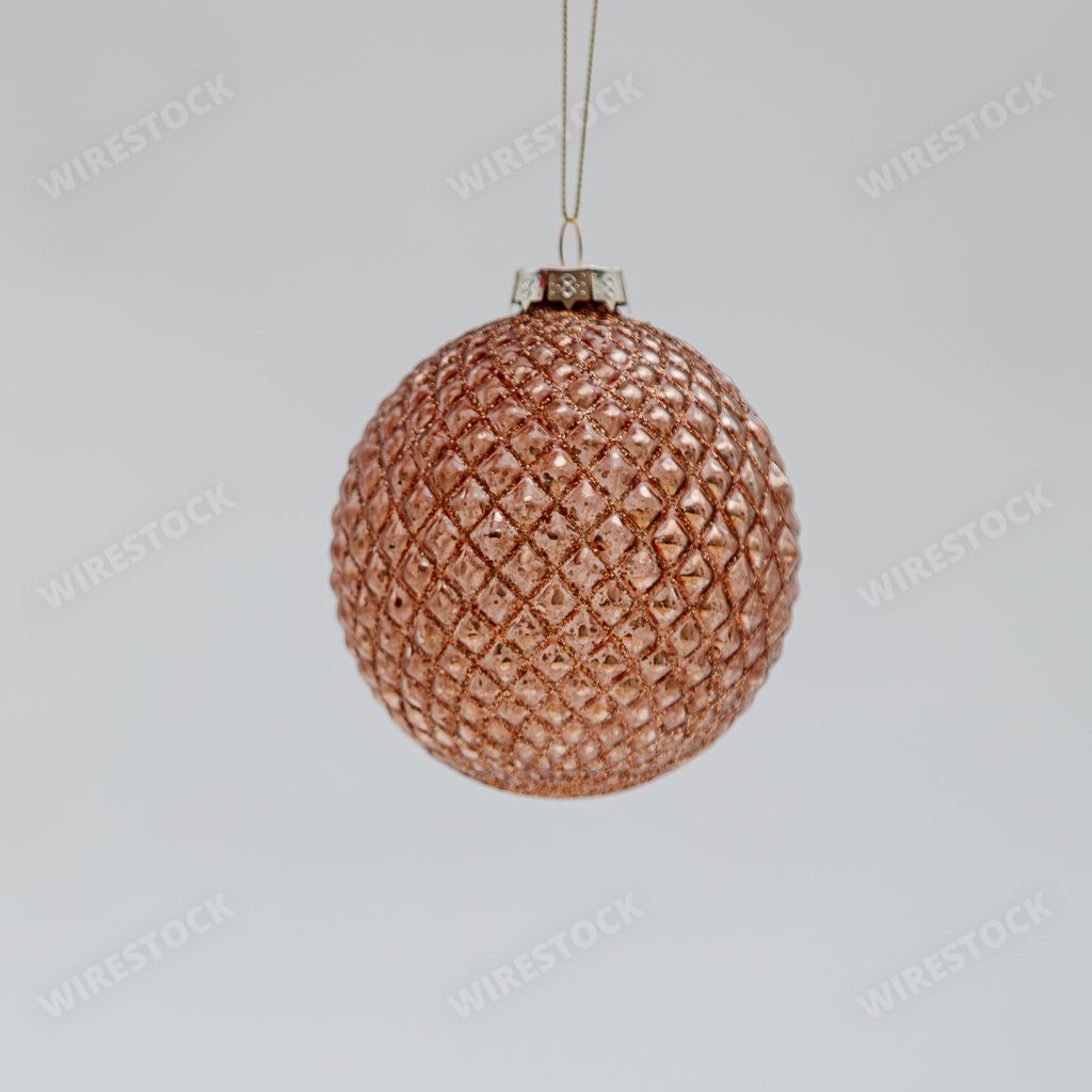 A bronze Christmas tree ball with tiny rhombus-shaped patterns