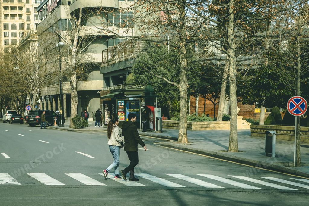 A selective focus of a couple crossing the pedestrian road in Baku, Azerbaijan