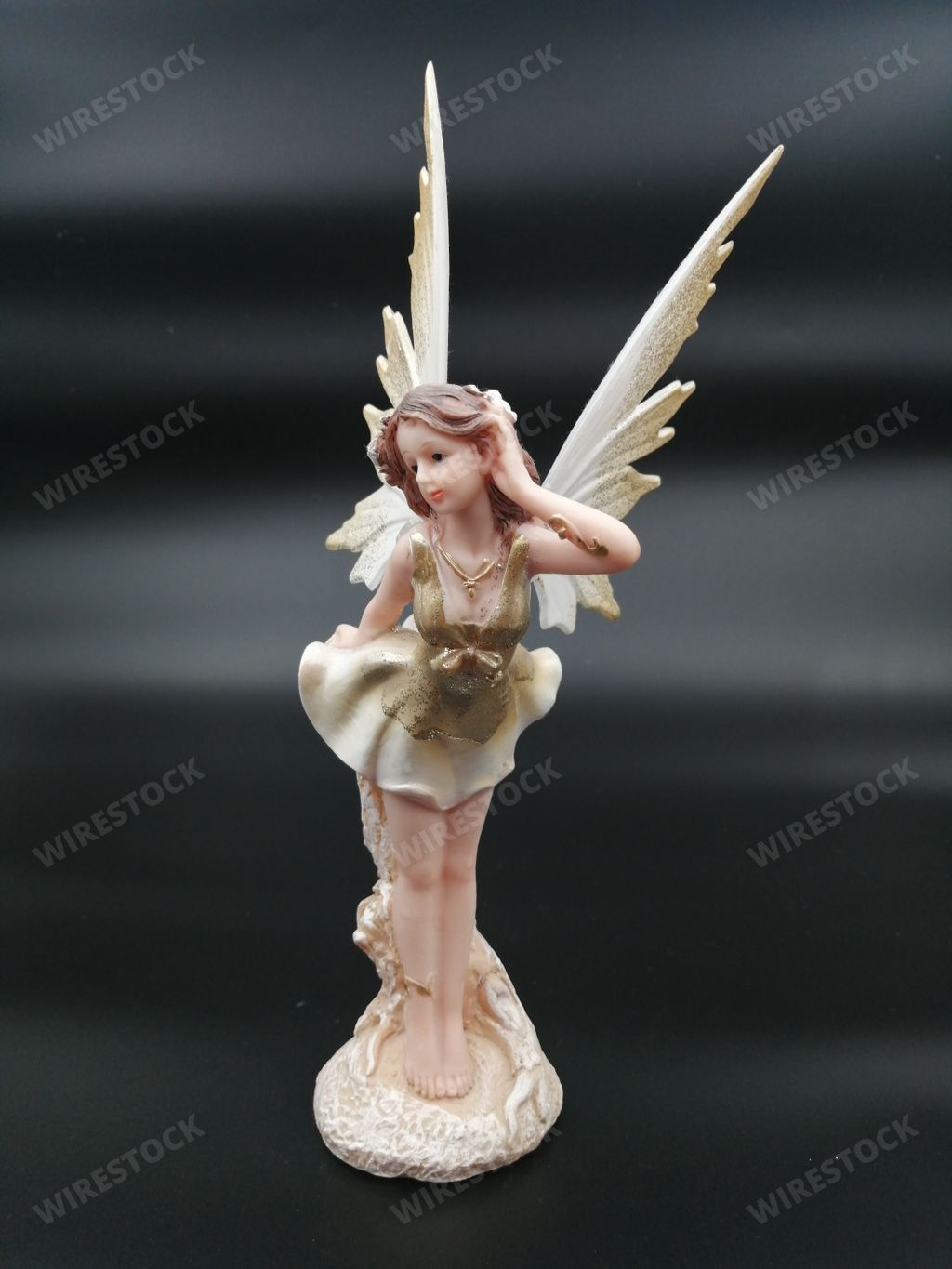 A vertical shot of an angel figurine isolated on black background