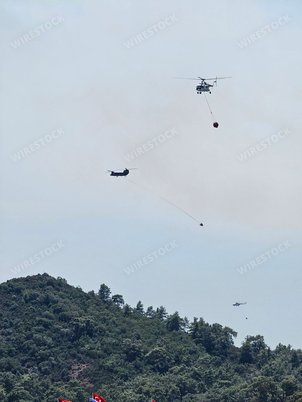 A majestic helicopter flying gracefully over boats and people in the clear blue sky, providing a stunning aerial view