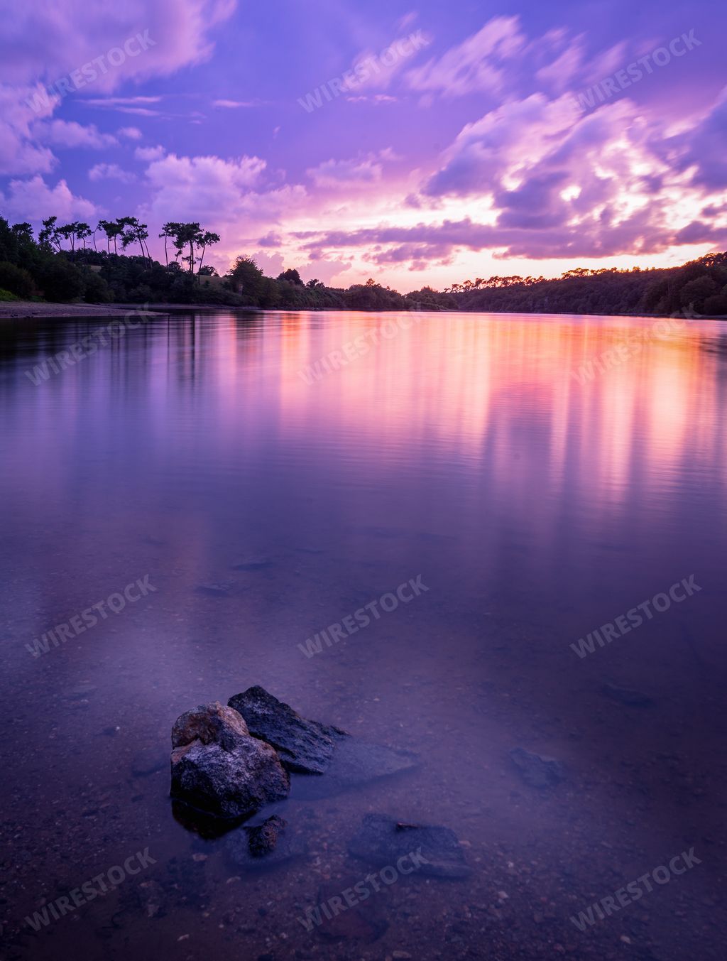 A breathtaking scenery of the sunset clouds reflecting in Lac du Jaunay, France