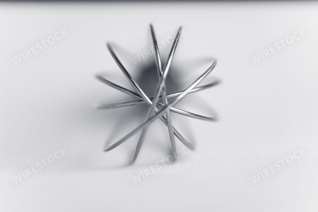 A macro shot of stainless steel whisk isolated on a white background