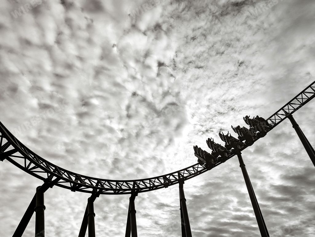 A low angle view of rollercoaster in background of sky in black and white