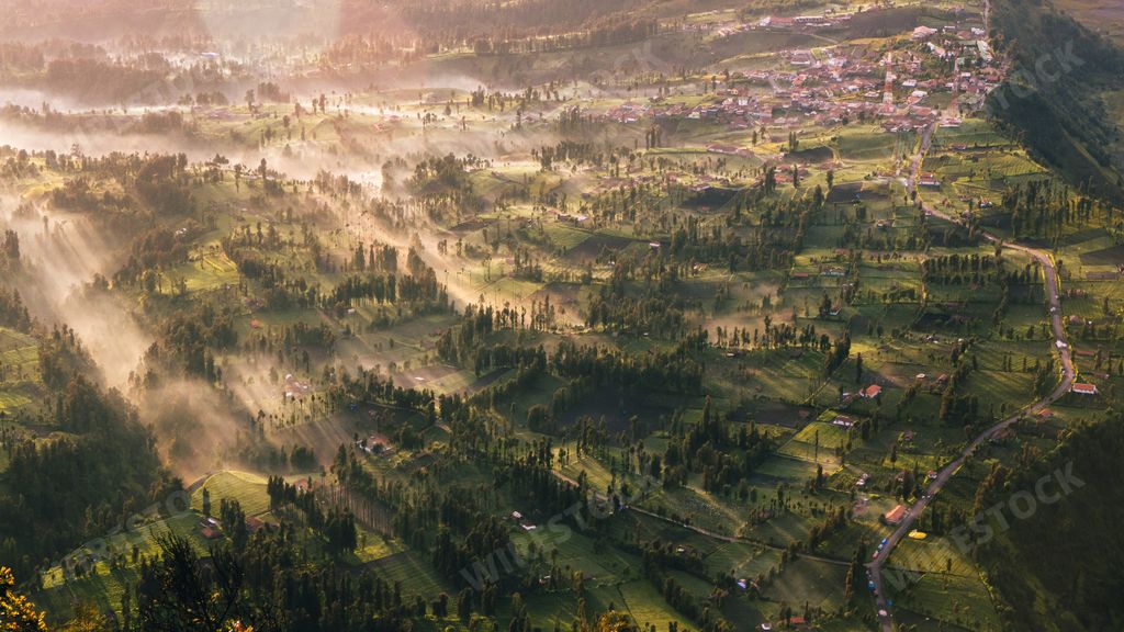 A landscape of a beautiful village covered in greenery during the sunrise in Java, Indonesia