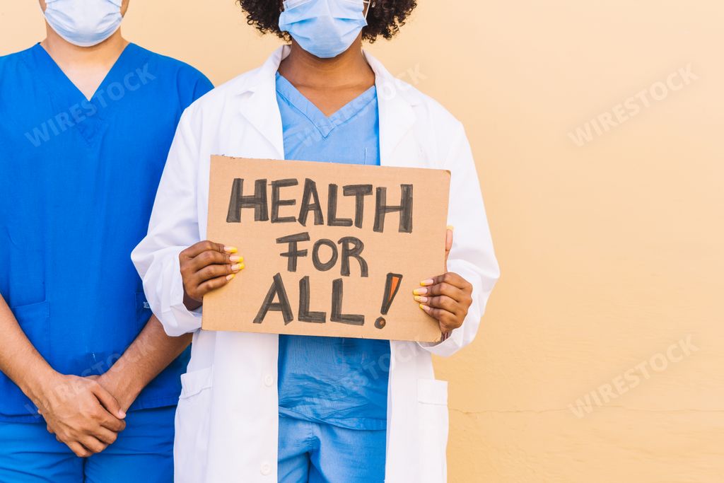 Two doctors or nurses wearing uniforms and sanitary masks holding a "Health for all" banner