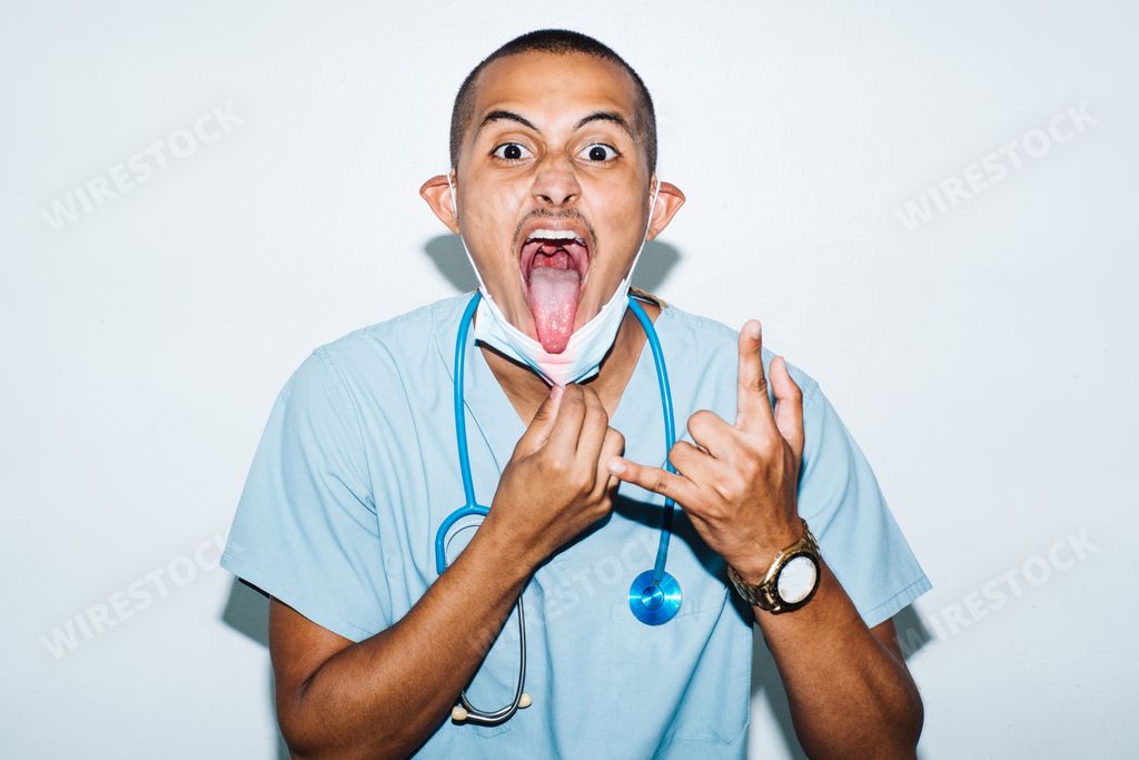 A portriat of a male latino doctor  with open mouth showing a peace sign gesture