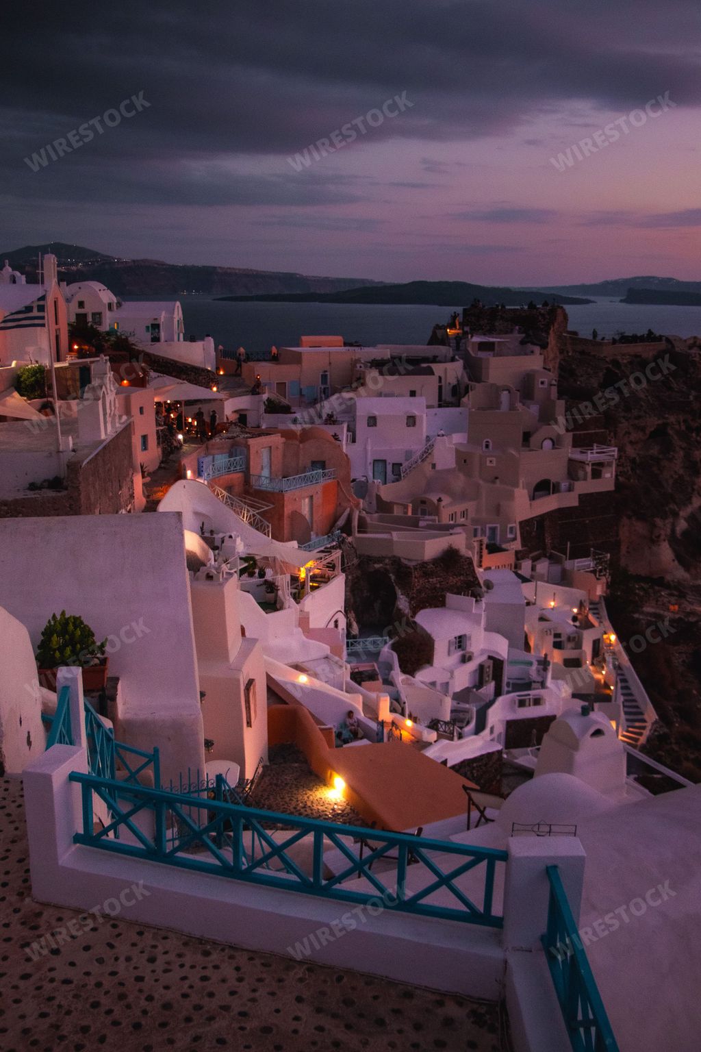 A breathtaking view of the village of Oia in Santorini, Greece under a dark pinkish sky at dusk