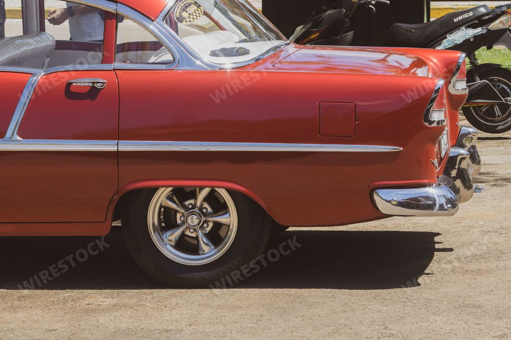 A closeup of the old red Chevrolet car back on a street