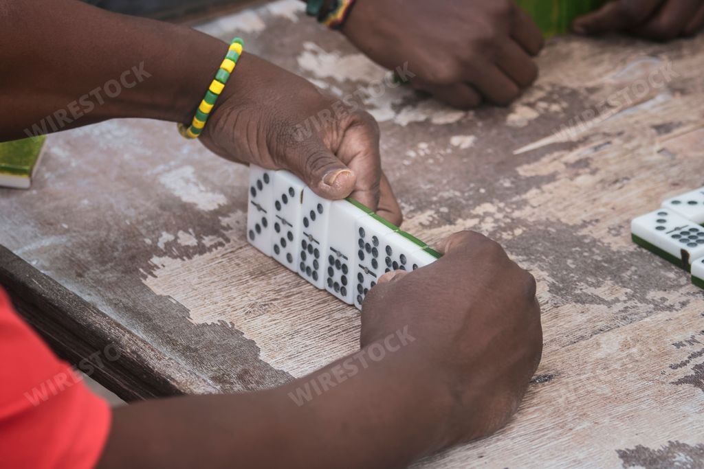 A closeup of black Latinos hands playing dominoes in the neighborhood of La Marina Matanzas, Cuba
