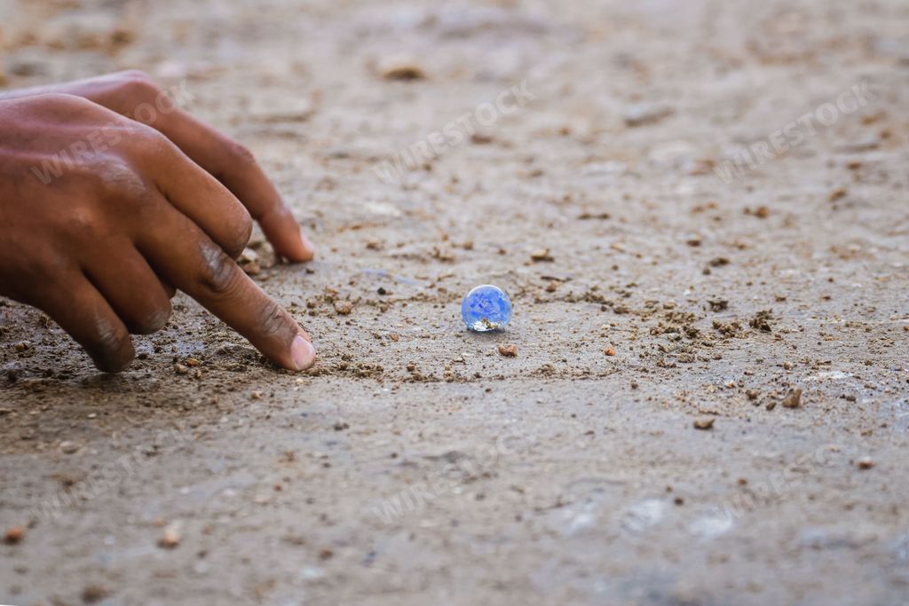 A closeup shot of a hand manipulating marble balls