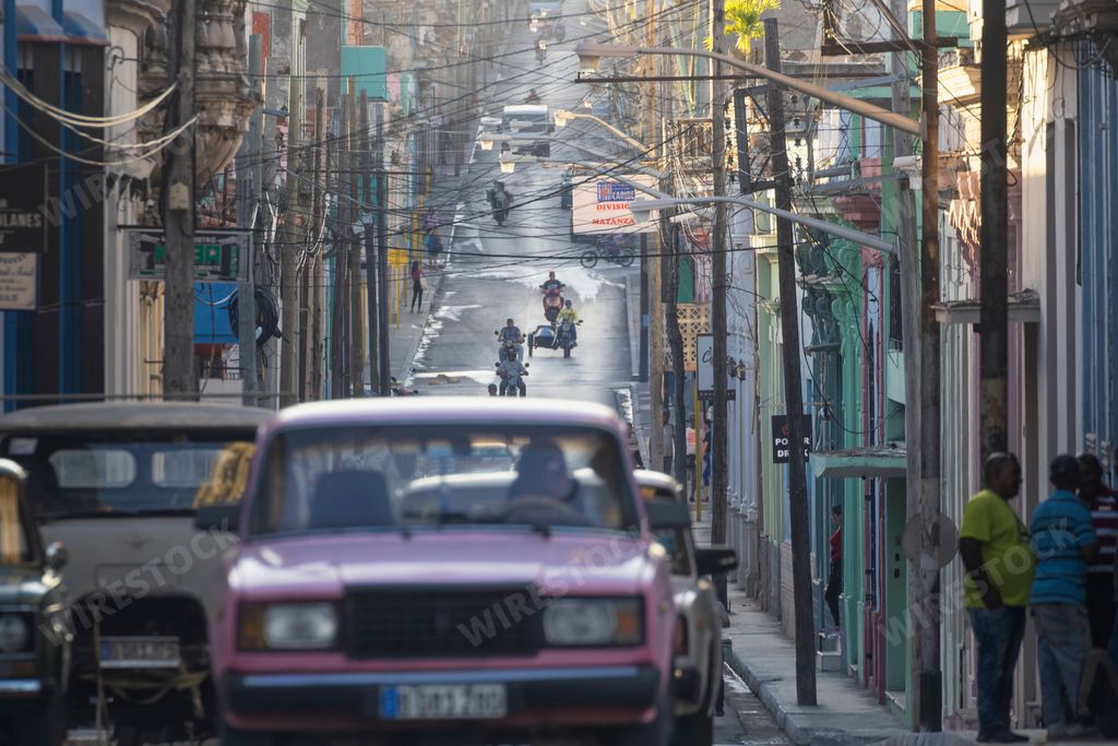 A road full of cars and motorbikes on Milanes Street in Matanzas, Cuba