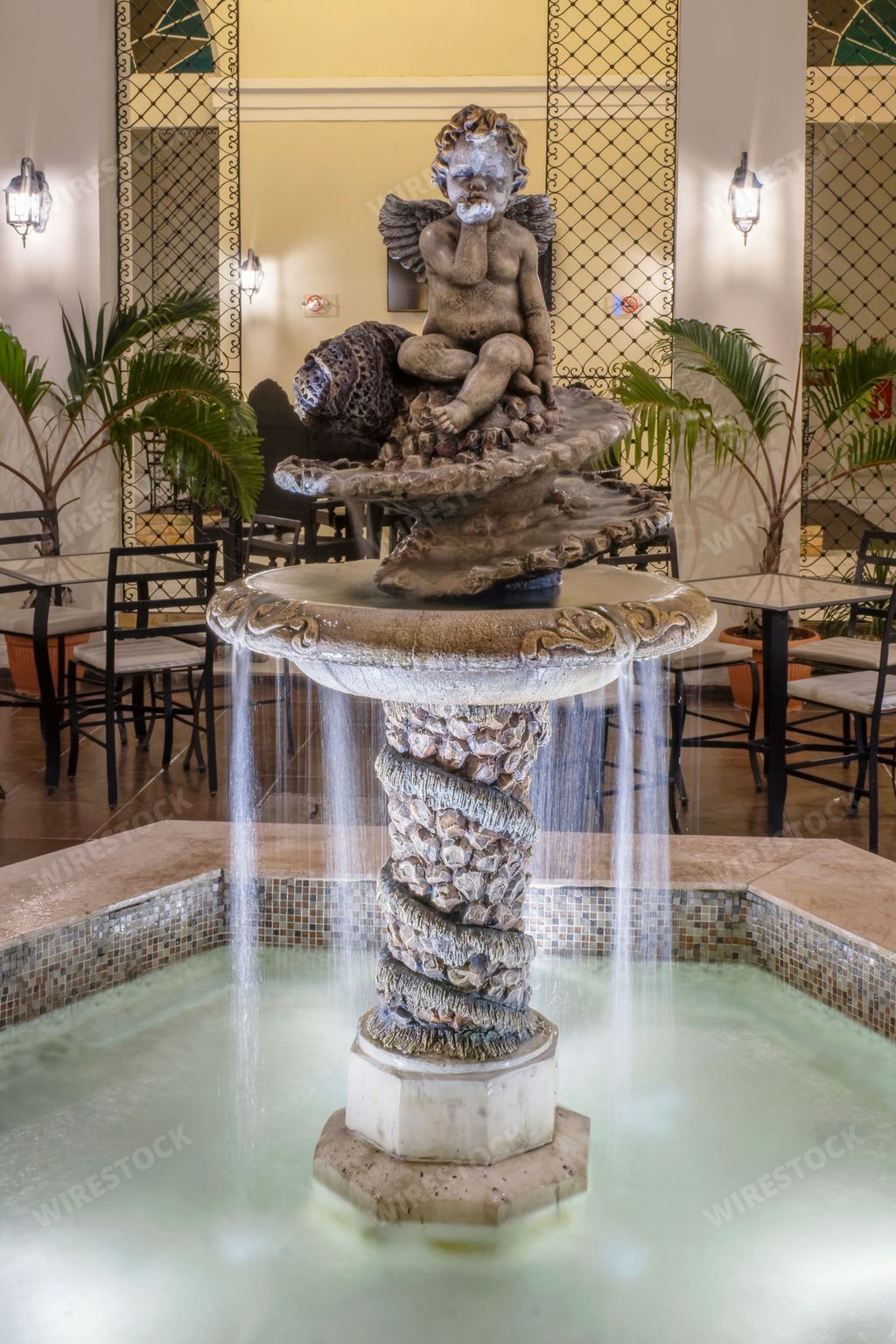 A vertical shot of a fountain of an angel in a hotel restaurant, Hotel E Louvre, matanzas, Cuba