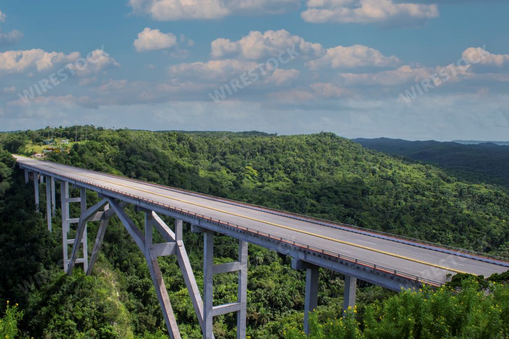 An aerial view of the famous Bridge of Bacunayagua surrounded by trees and mountains in Cuba