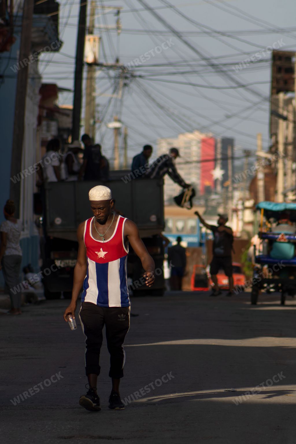 A vertical shot of a man in a t-shirt with Cuban flag