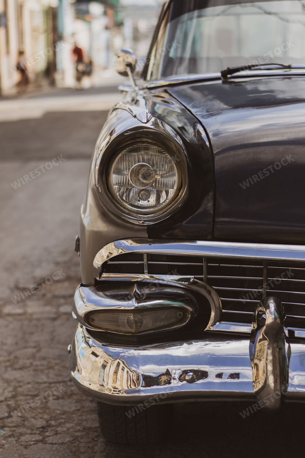 A vertical shot of a front part of a beautiful black retro car