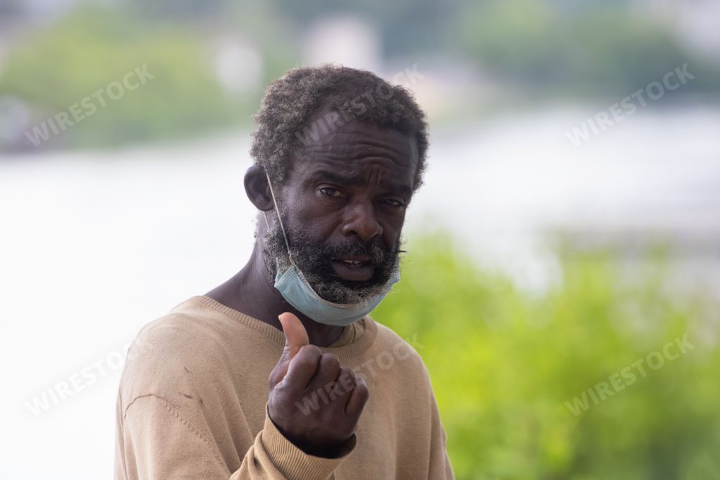 A poor Cuban man with a face mask under his chin in a street in Matanzas